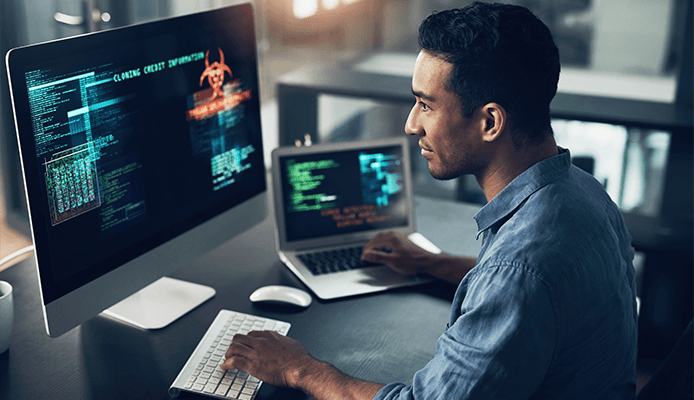 Man working at desk with two screens