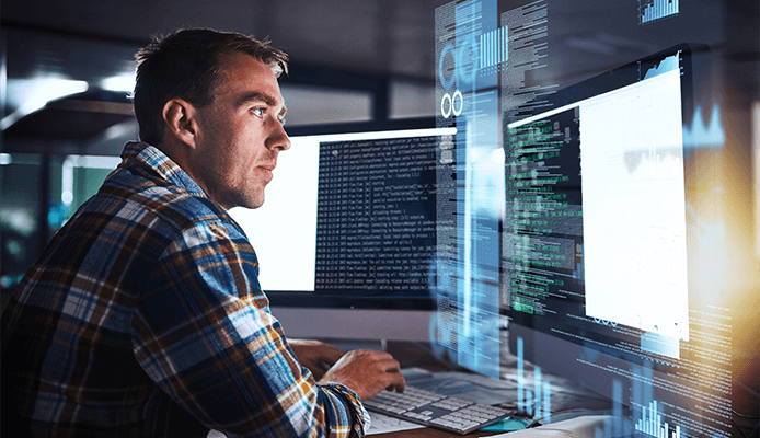 Man working at desk on computer with code